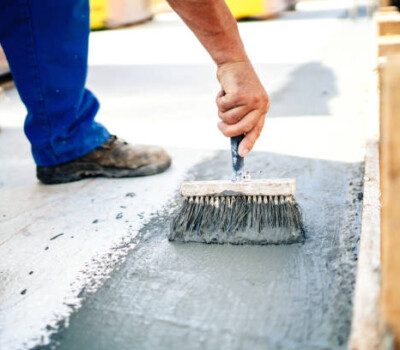 construction worker using brush and primer for hydroisolating and waterproofing house